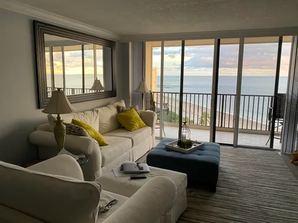 a living room with furniture and a floor to ceiling window