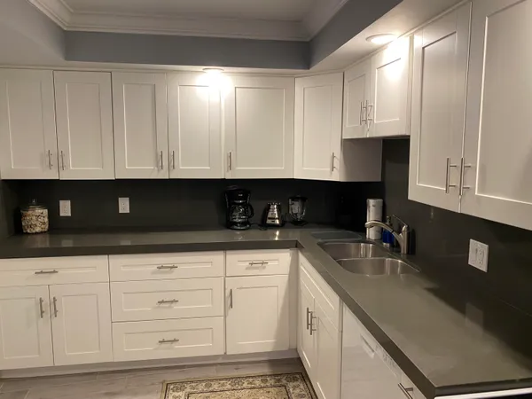 a kitchen with white cabinets and sink