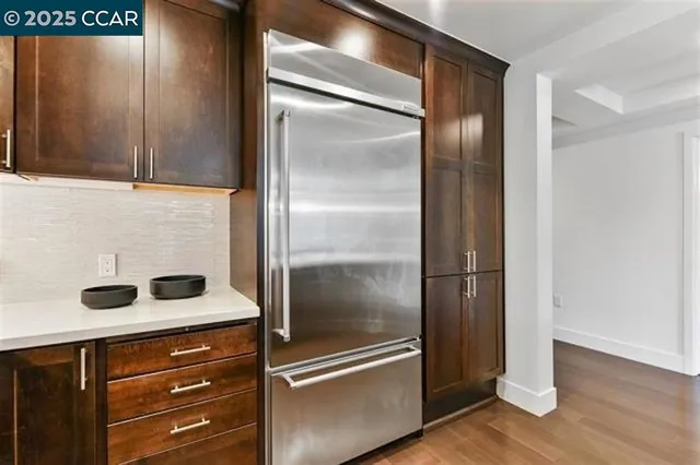 a kitchen with a refrigerator and wooden cabinets