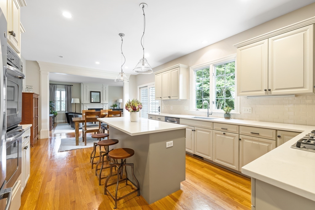 80 Emerson Road Needham, MA 02492 - Photo 8 of 41 a kitchen with stainless steel appliances granite countertop sink stove and white cabinets with wooden floor