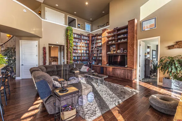 a view of a dining room and livingroom with furniture wooden floor a chandelier