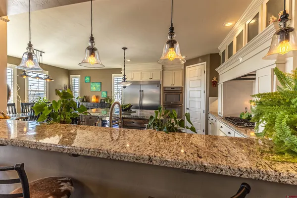 a kitchen with stainless steel appliances granite countertop a stove a sink and a refrigerator