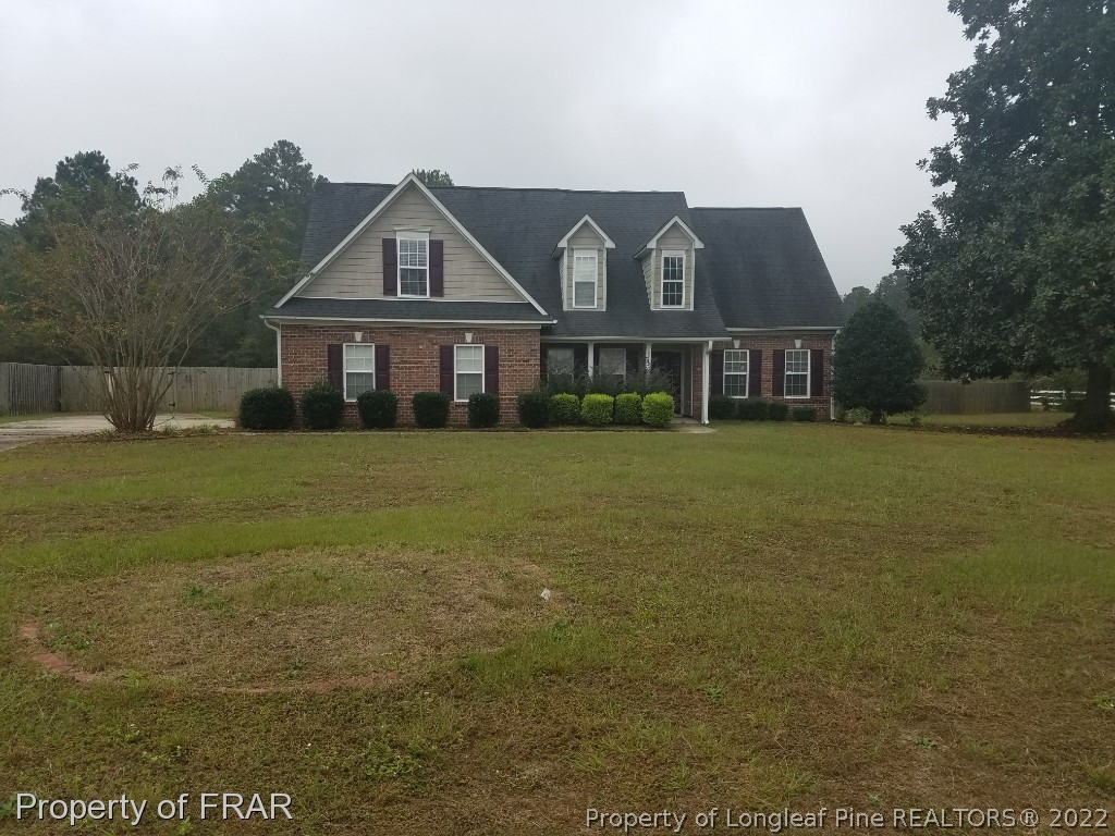 6715 Valley Falls Road Hope Mills, NC 28348 - Photo 1 of 13 a view of a big house with a big yard and large trees