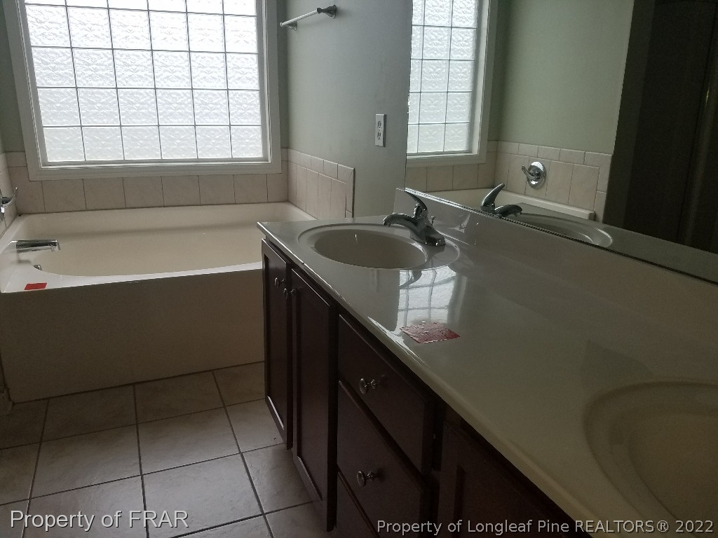 6715 Valley Falls Road Hope Mills, NC 28348 - Photo 8 of 13 a bathroom with a sink a bathtub and next to a window