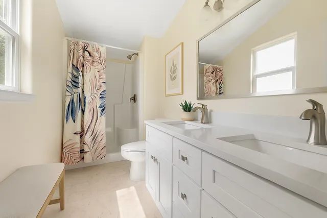 a bathroom with a sink a toilet and a shower