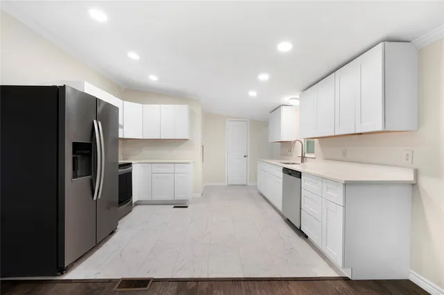 a kitchen with white cabinets and stainless steel appliances