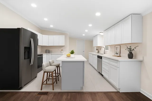a kitchen with a sink a refrigerator and white cabinets