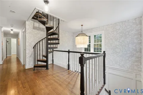 a view of a livingroom with wooden floor and stairs