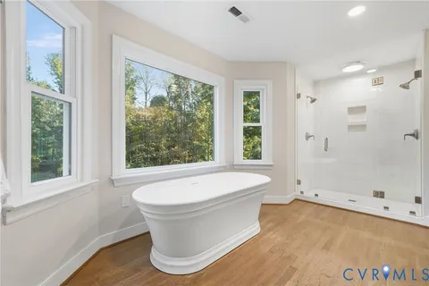 a white bath tub sitting in a bathroom next to a window
