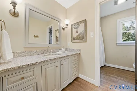 a bathroom with a granite countertop sink mirror and vanity