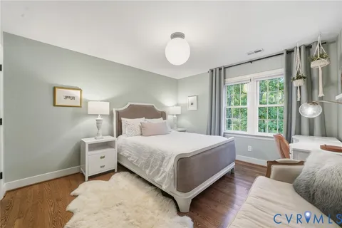 a bedroom with a bed lamp and a large window