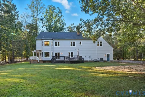 a view of a house with a big yard and large trees