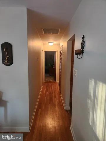 a view of a hallway with wooden floor