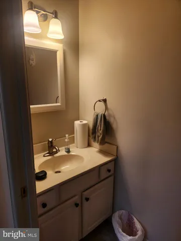 a bathroom with a sink vanity and mirror