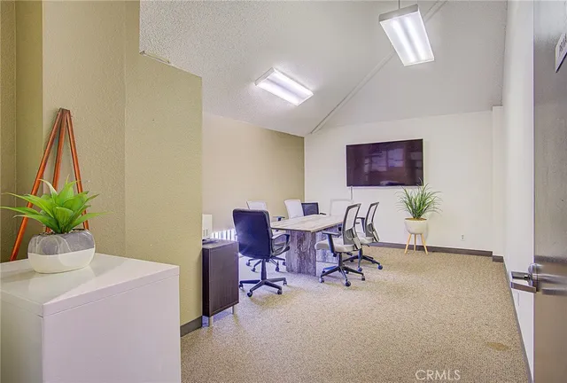 a living room with furniture a flat screen tv and a table