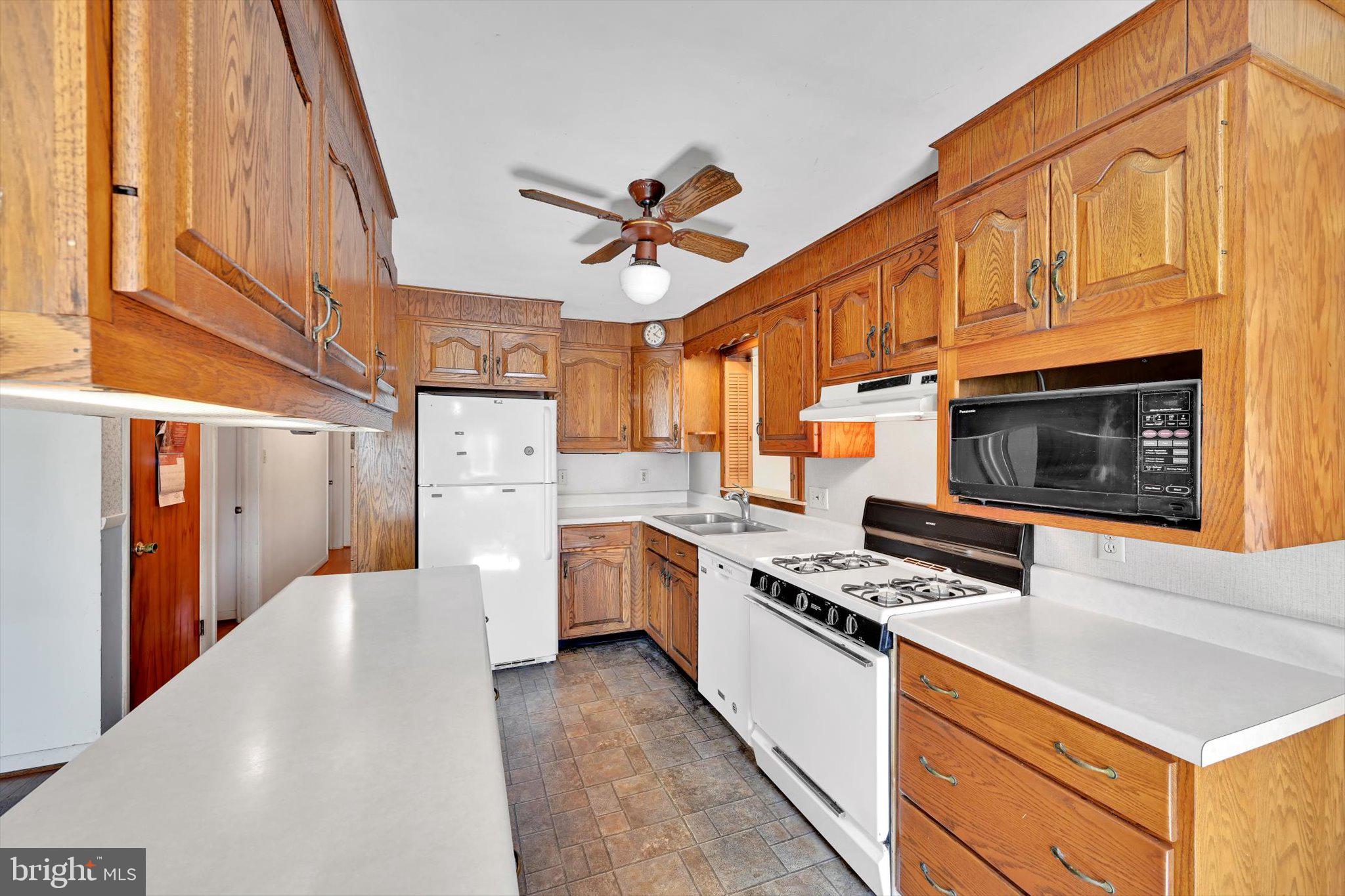 322 Morrison Road Reading, PA 19601 - Photo 6 of 29 a kitchen with stainless steel appliances a stove a sink dishwasher and a refrigerator with wooden floor