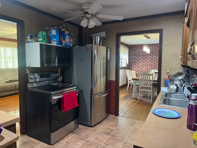 a kitchen with stainless steel appliances granite countertop a refrigerator a stove and a sink