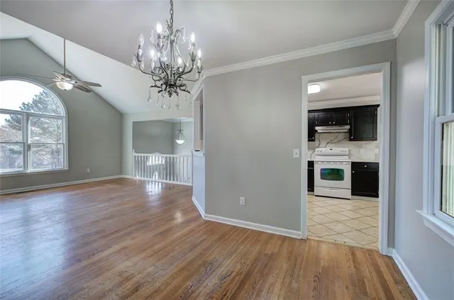 a view of a hallway with wooden floor and a kitchen