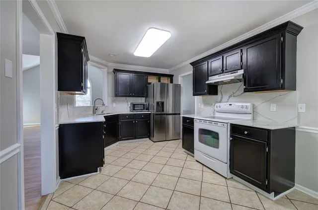 a kitchen with stainless steel appliances granite countertop a refrigerator and a stove top oven