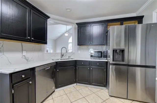 a kitchen with a sink a refrigerator and cabinets