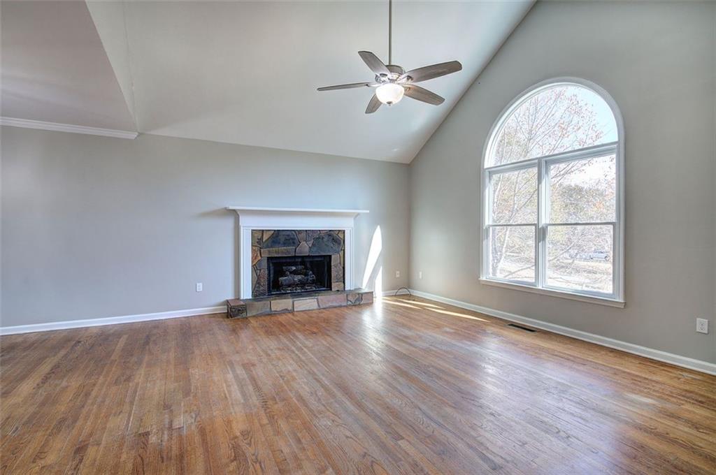 33 Engineer Lane Cartersville, GA 30120 - Photo 7 of 39 an empty room with wooden floor fireplace and windows