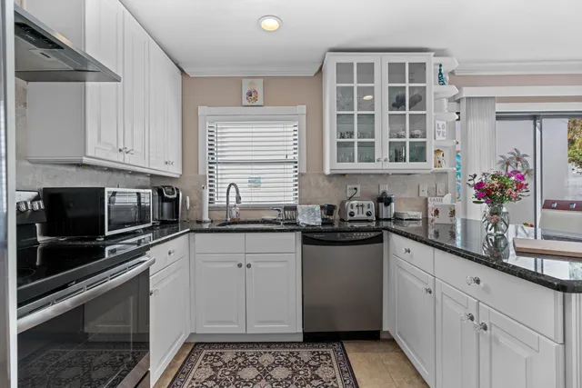 a kitchen with stainless steel appliances granite countertop a sink stove and cabinets