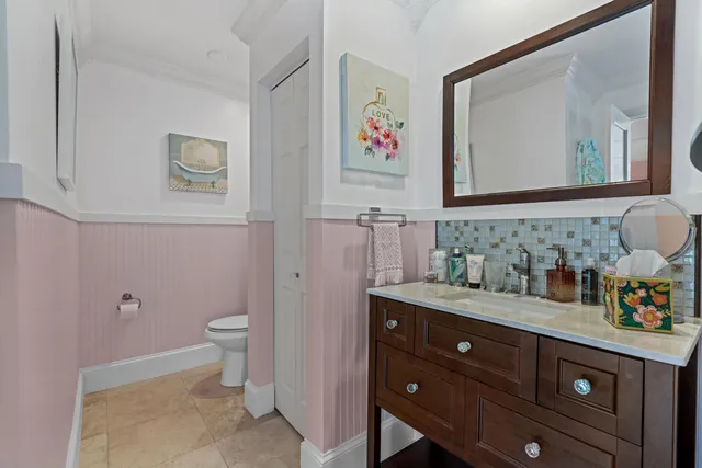 a bathroom with a granite countertop sink mirror vanity and toilet