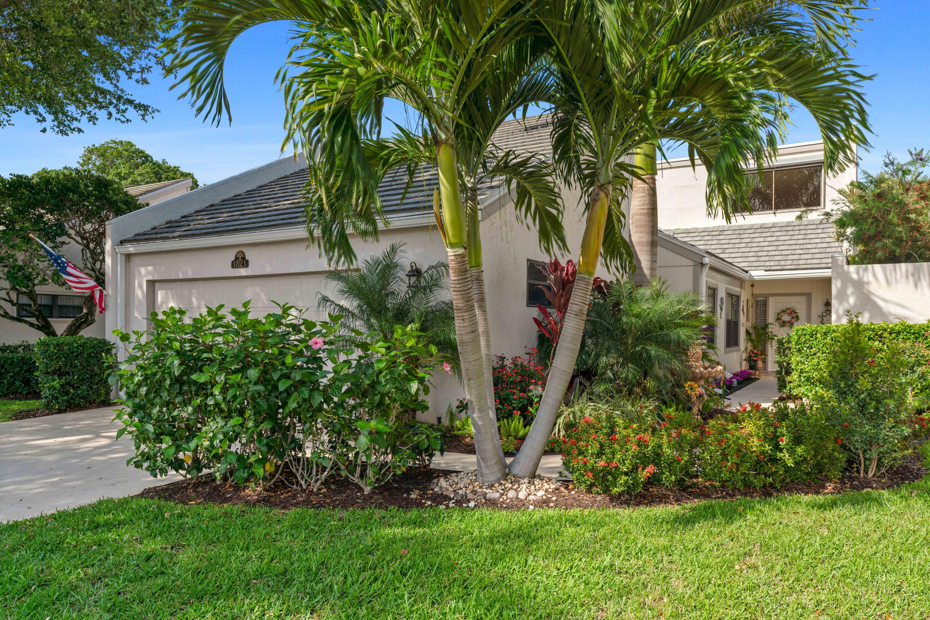 17023 Traverse Circle Jupiter, FL 33477 - Photo 2 of 35 a view of a house with a tree and plants