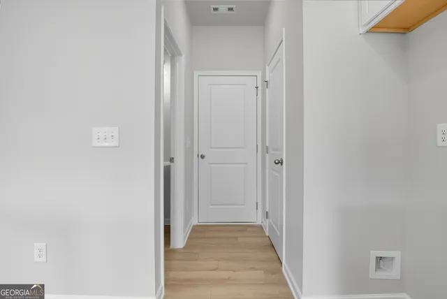 a view of a hallway with wooden floor