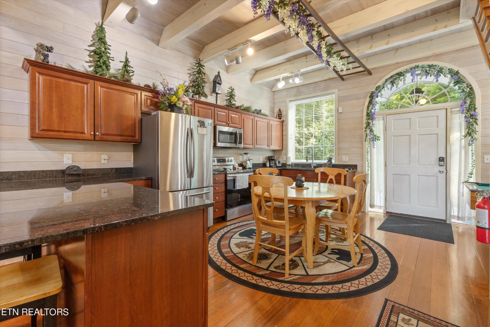 3638 Locust Ridge Road Sevierville, TN 37876 - Photo 12 of 50 a kitchen with a refrigerator a stove and a dining table with wooden floor
