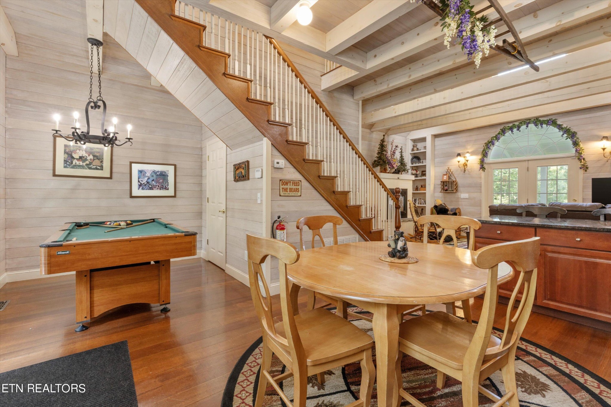 3638 Locust Ridge Road Sevierville, TN 37876 - Photo 17 of 50 a dining room with wooden floor a chandelier a wooden table and chairs