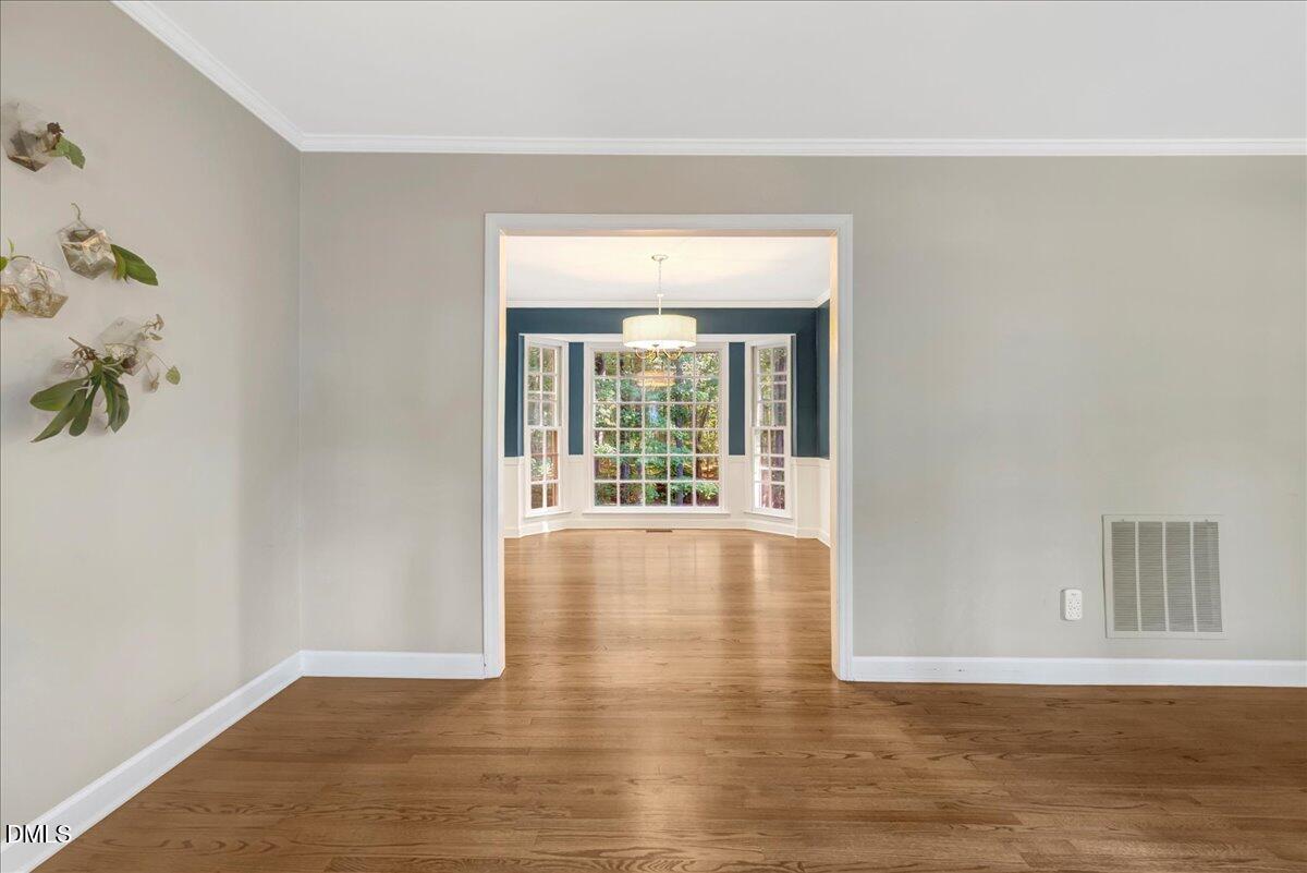 11808 Edgewater Court Raleigh, NC 27614 - Photo 14 of 56 a view of an empty room with wooden floor and a window