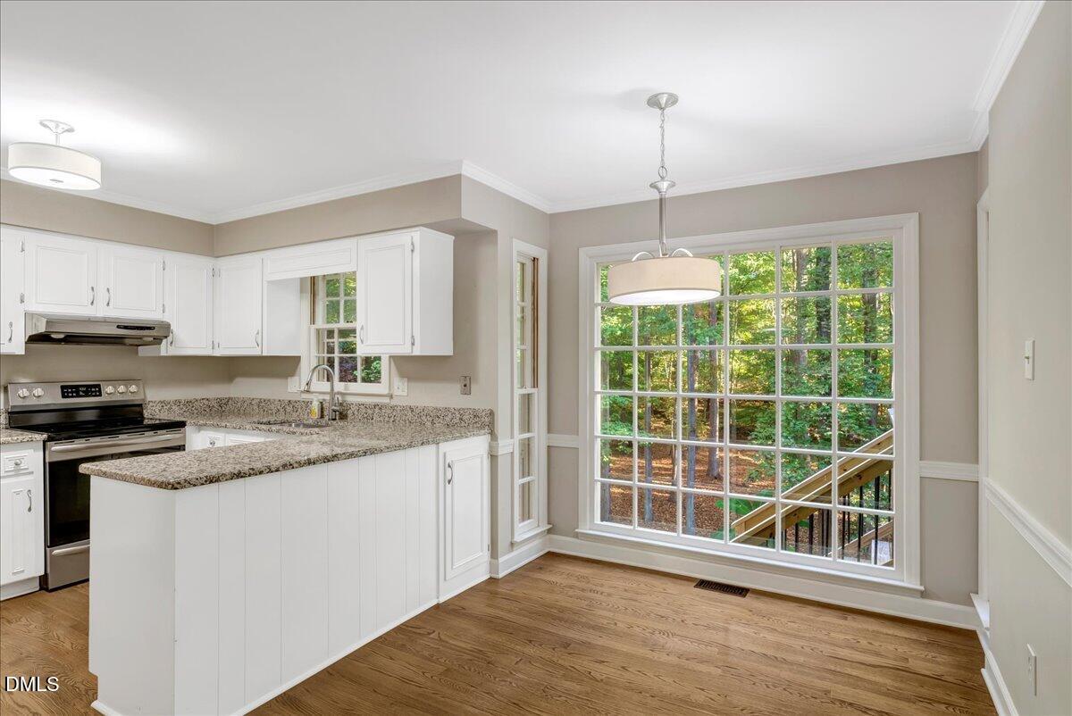 11808 Edgewater Court Raleigh, NC 27614 - Photo 48 of 56 a kitchen with stainless steel appliances granite countertop a stove a sink and white cabinets