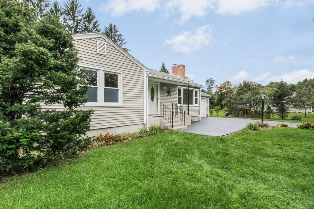 a view of a house with a backyard and a tree