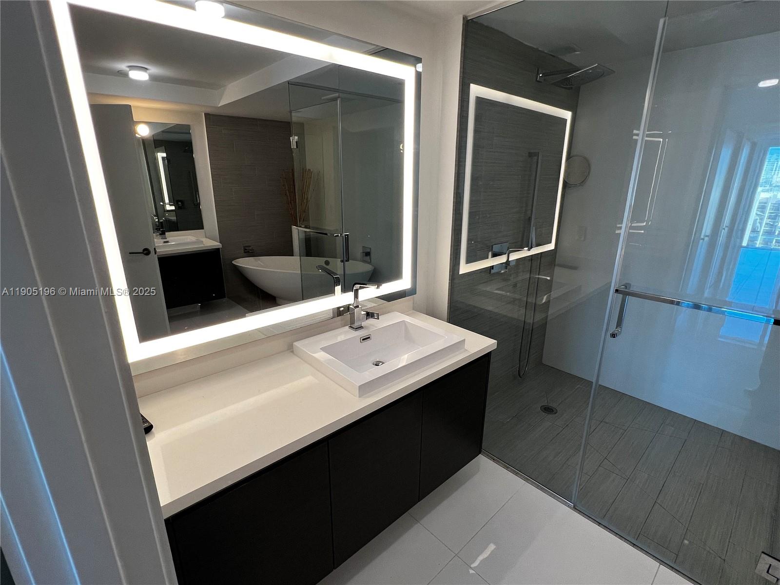 300 Sunny Isles Boulevard, Unit 4901 Sunny Isles Beach, FL 33160 - Photo 11 of 22 a bathroom with a sink a mirror and a shower