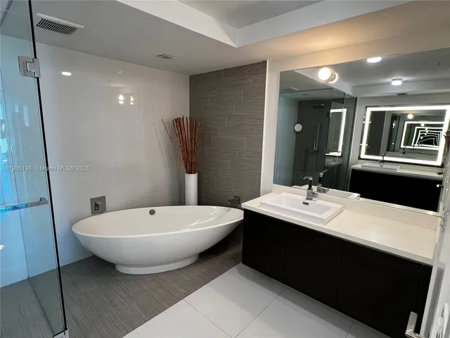a bathroom with a sink shower and a mirror