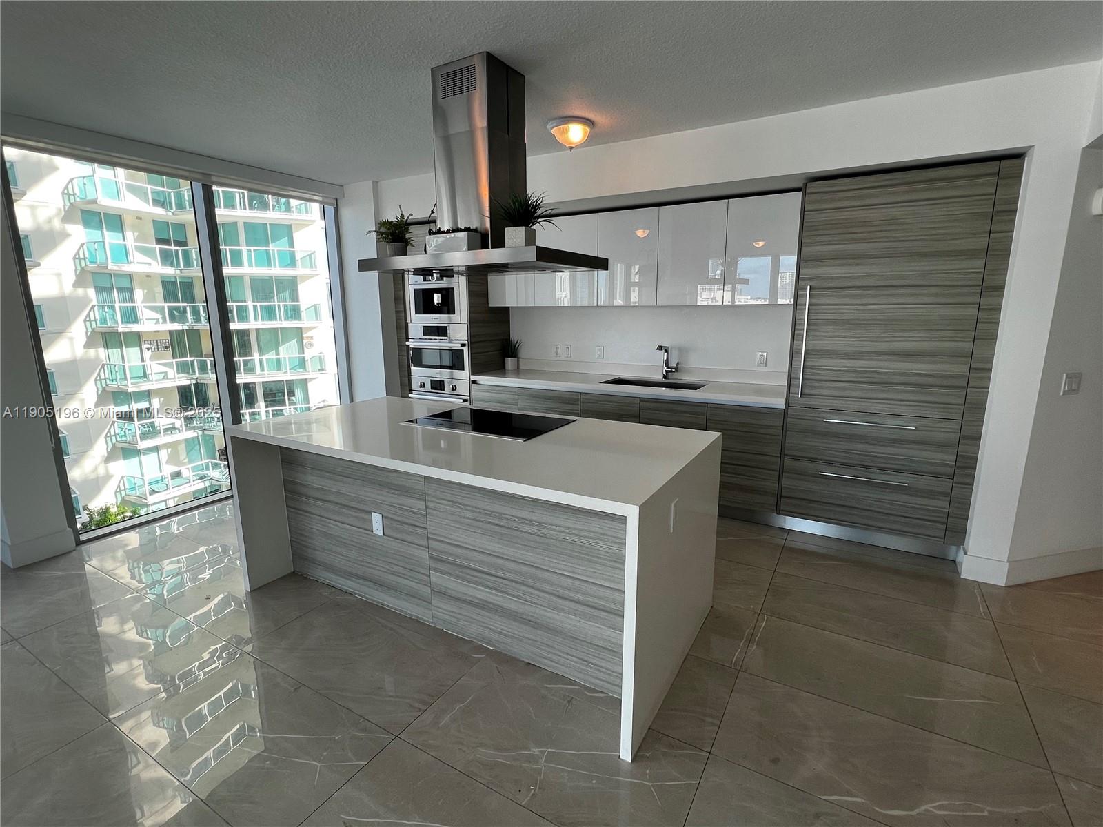 300 Sunny Isles Boulevard, Unit 4901 Sunny Isles Beach, FL 33160 - Photo 7 of 22 a kitchen with kitchen island a sink stainless steel appliances and cabinets