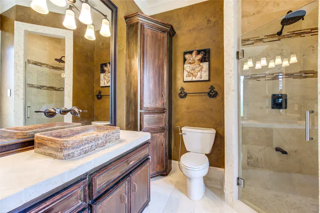 a bathroom with a granite countertop sink toilet a shower and a mirror