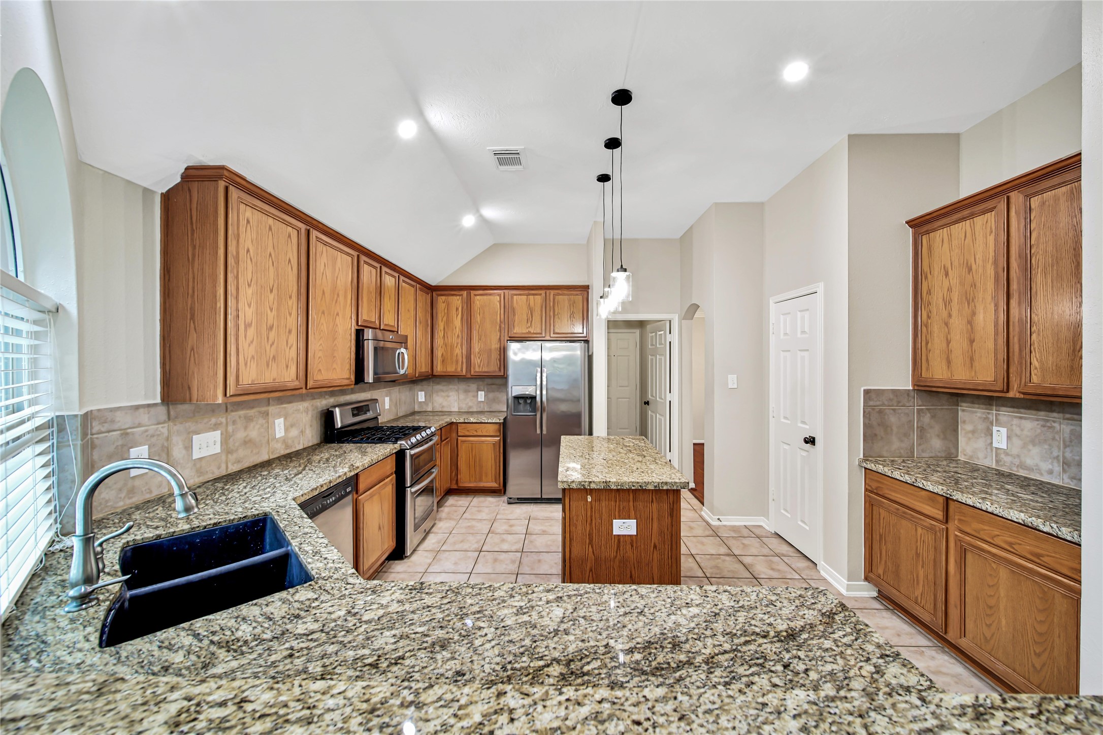 14526 Red Tailed Hawk Lane Houston, TX 77044 - Photo 8 of 40 a large kitchen with kitchen island granite countertop a sink and wooden cabinets