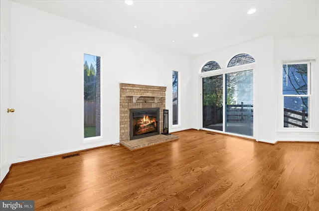 a view of a kitchen with a sink dishwasher a kitchen island with wooden floor and cabinets
