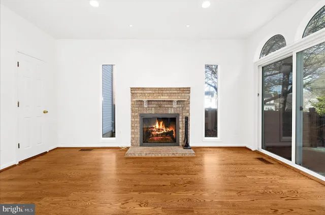 an empty room with windows and fireplace
