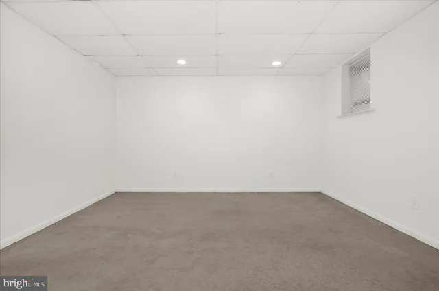 an empty room with wooden floor closet and windows