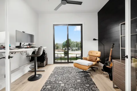 a view of a workspace with furniture and a window