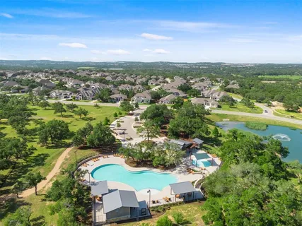 an aerial view of residential houses with outdoor space and trees