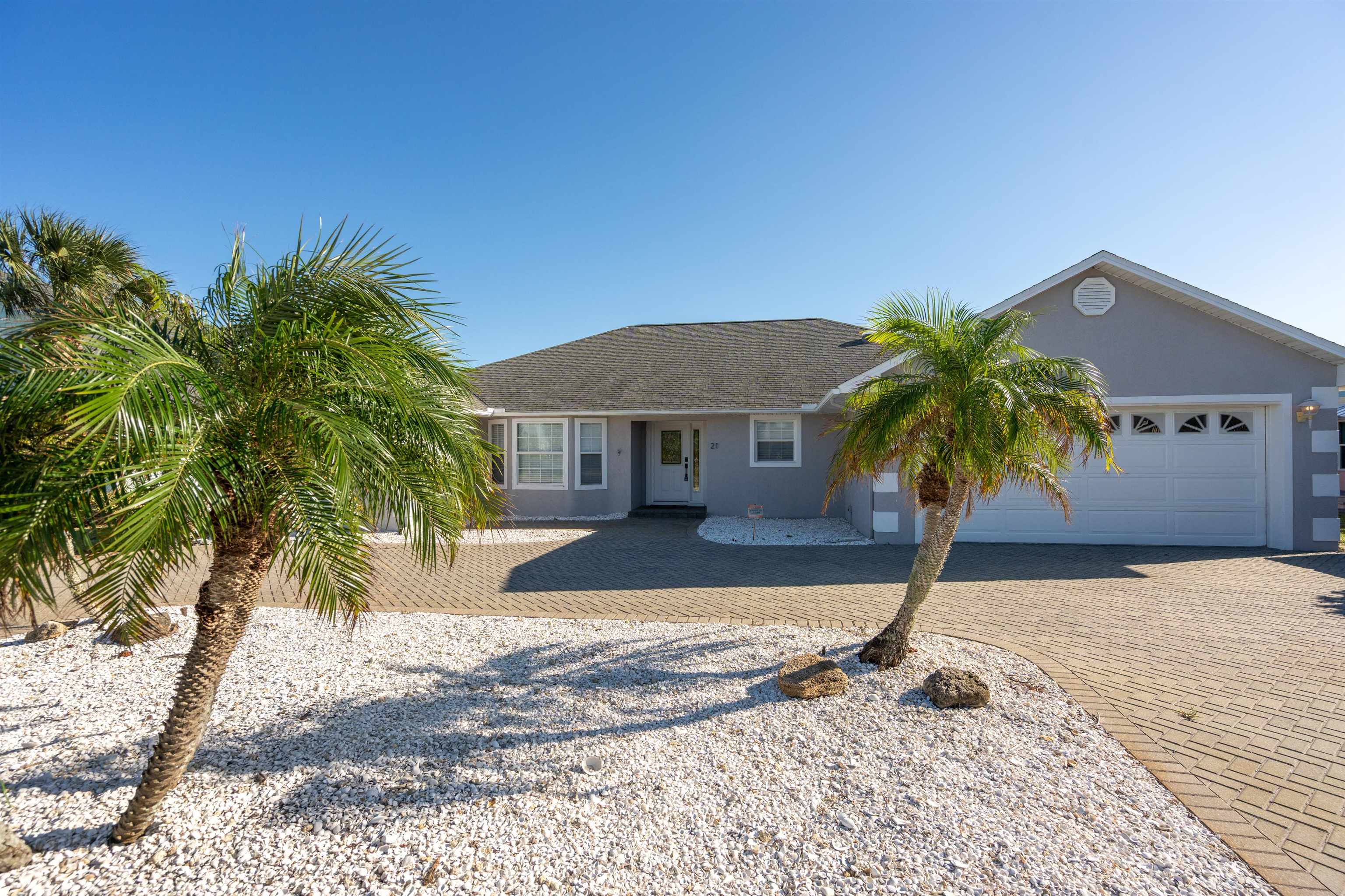 21 Ocean Trace Road St. Augustine, FL 32080 - Photo 16 of 48 a palm tree sitting in front of a house with a yard