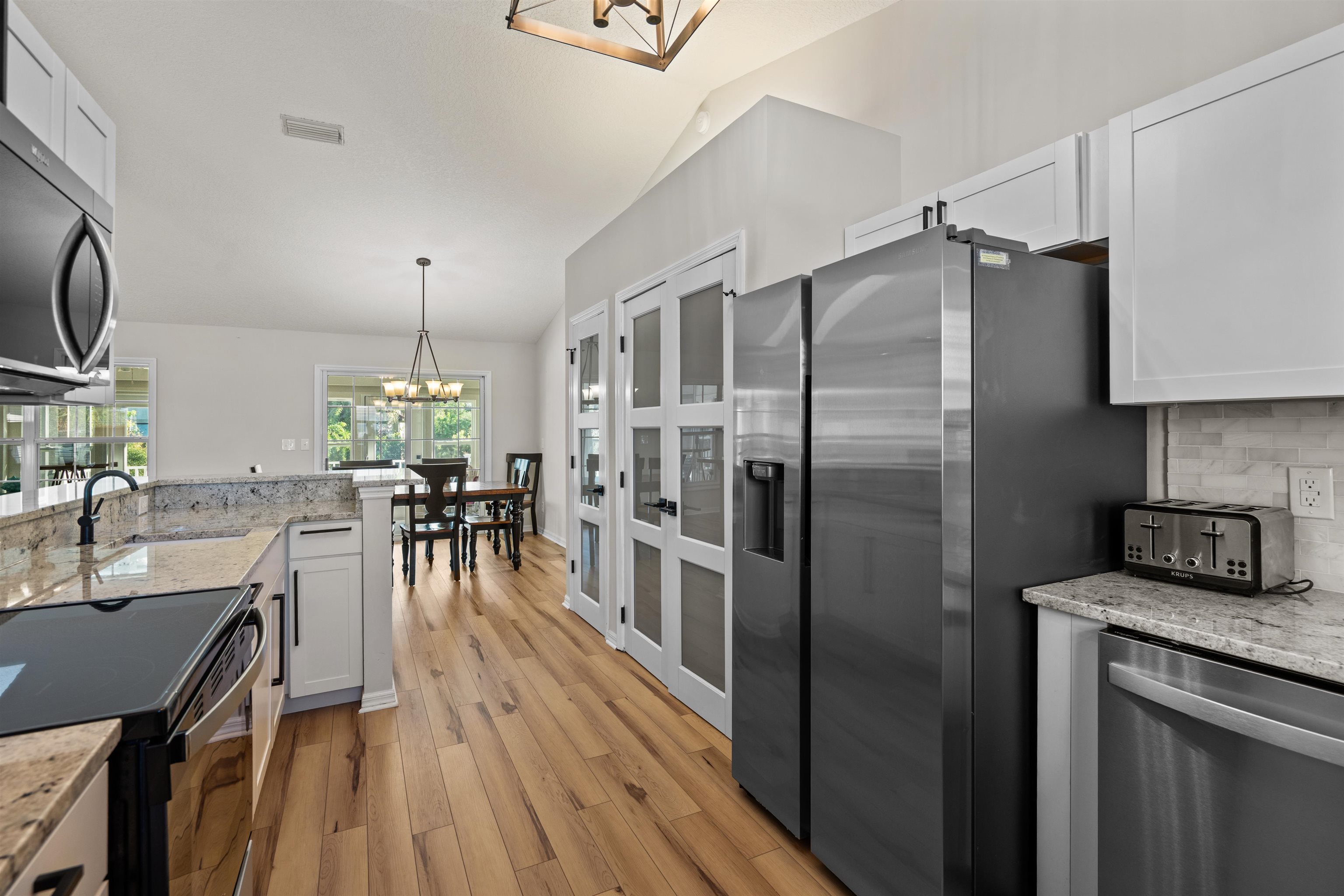 21 Ocean Trace Road St. Augustine, FL 32080 - Photo 19 of 48 a kitchen with stainless steel appliances granite countertop a refrigerator a stove and a wooden floors