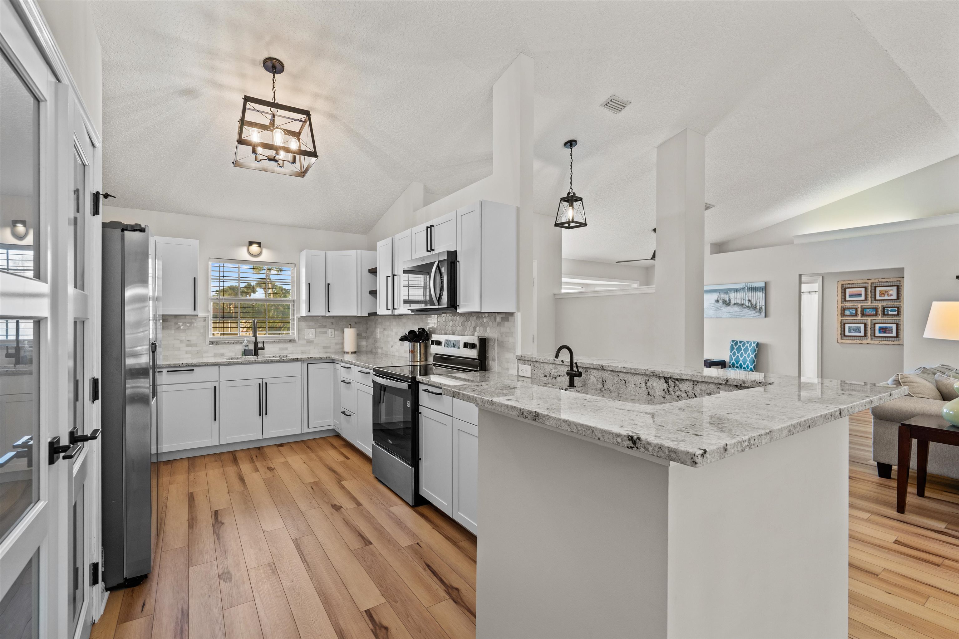 21 Ocean Trace Road St. Augustine, FL 32080 - Photo 4 of 48 a kitchen with white cabinets sink and refrigerator