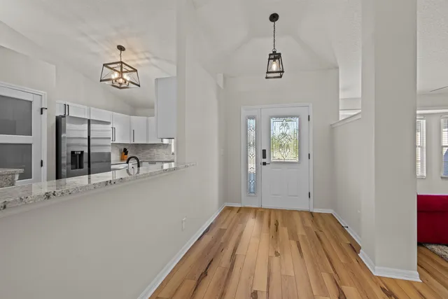 a kitchen with stainless steel appliances granite countertop a refrigerator a stove and a wooden floors