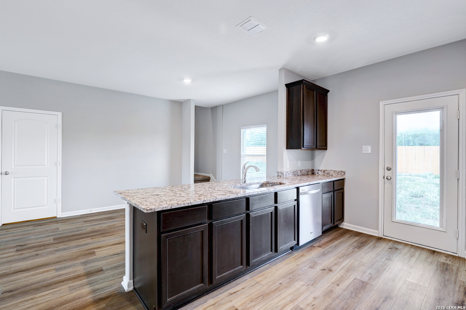 6403 Warhol Cape Converse, TX 78109 - Photo 14 of 29 a kitchen with stainless steel appliances granite countertop wooden cabinets a sink and dishwasher with wooden floor