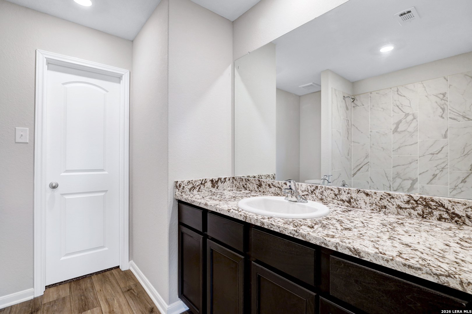 6403 Warhol Cape Converse, TX 78109 - Photo 19 of 29 a bathroom with a granite countertop sink and a mirror